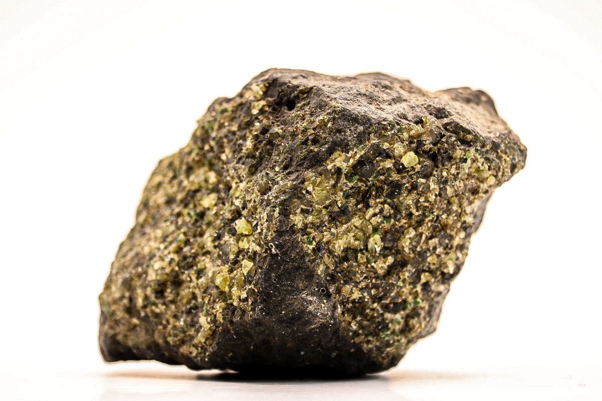 Detail van ruwe peridoot met kleine glinsterende groene kristallen